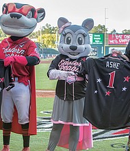 The late Richmond native and tennis great Arthur Ashe Jr. is remembered and honored with jerseys bearing his name during the All-Star Game at the baseball stadium located on Richmond’s Arthur Ashe Boulevard. Showing the jerseys to the crowd are, from left, Ben Rothrock, the Squirrels’ general manager; team mascots Nutzy and Nutasha; and Todd “Parney” Parnell, the Squirrels’ vice president and chief operating officer.