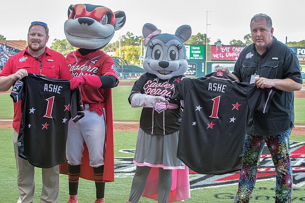 The late Richmond native and tennis great Arthur Ashe Jr. is remembered and honored with jerseys bearing his name during the All-Star Game at the baseball stadium located on Richmond’s Arthur Ashe Boulevard. Showing the jerseys to the crowd are, from left, Ben Rothrock, the Squirrels’ general manager; team mascots Nutzy and Nutasha; and Todd “Parney” Parnell, the Squirrels’ vice president and chief operating officer.