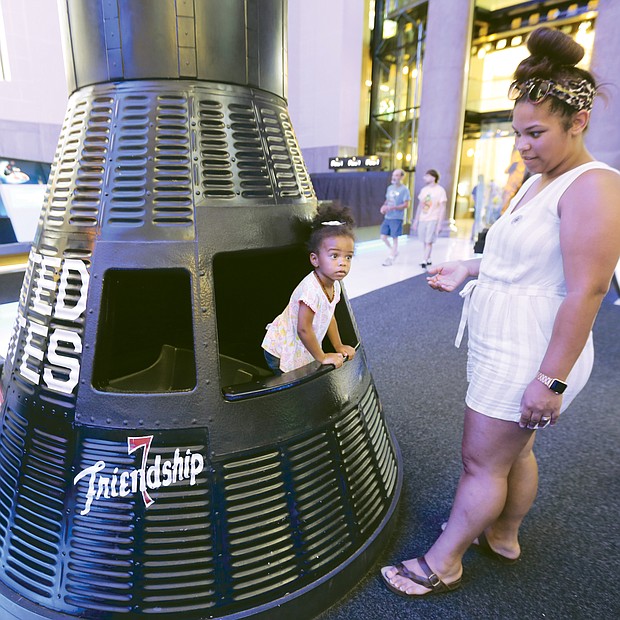 Out of this world/
 Harper Miller peers out from her perch in a replica of Friendship 7, the Mercury capsule in which astronaut John H. Glenn Jr. became the first American to orbit the Earth in February 1962. The youngster was visiting the Science Museum of Virginia with her mom, Kali Miller, and other family members last Saturday as part of the 50th anniversary celebration of the Apollo 11 landing on the moon.