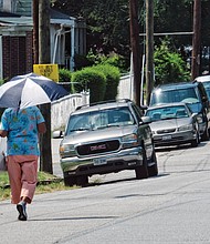 Beating the heat/
When temperatures settled in the 90s around Richmond and no relief was in sight, Richmonders turned to all kinds of activities to beat the heat. Some folks opened umbrellas to take shelter from the blazing sun, like the pedestrian walking along 19th and U streets in the East End last Saturday. (Sandra Sellars/Richmond Free Press)