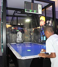 Power Scholar Shawn Clark, 8, challenges the museum’s air hockey robot to a fast and exciting game.
