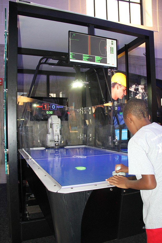 Power Scholar Shawn Clark, 8, challenges the museum’s air hockey robot to a fast and exciting game.