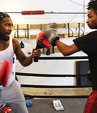 Cherry Pick’d Boxing/
Coach and trainer Tony Cherry, left, helps Deon Jones, 13, hone his skills at Cherry Pick’d Boxing. (Regina H. Boone/Richmond Free Press)