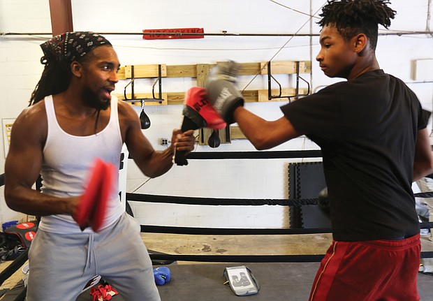 Cherry Pick’d Boxing/
Coach and trainer Tony Cherry, left, helps Deon Jones, 13, hone his skills at Cherry Pick’d Boxing. (Regina H. Boone/Richmond Free Press)