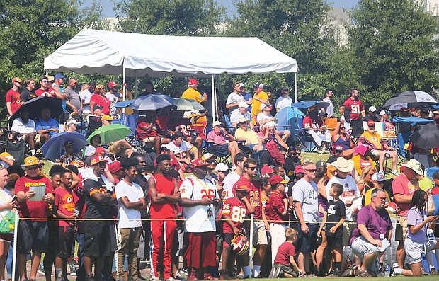 Hundreds of fans watch the Washington NFL team’s training session on Saturday. The training camp will continue, and be open to fans, through Aug. 11.