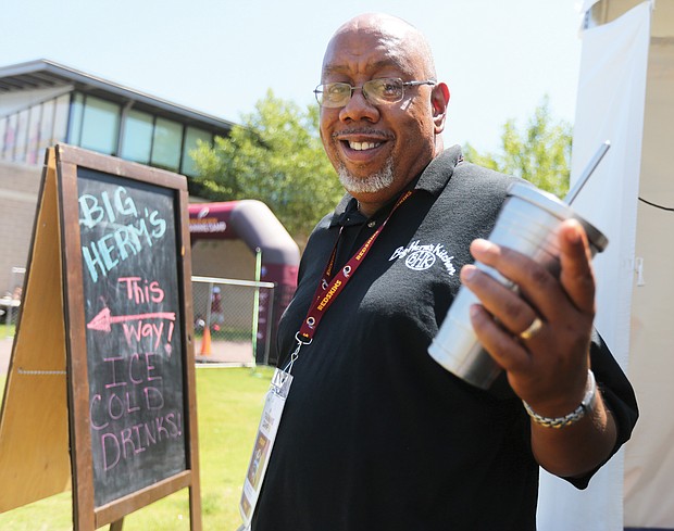 Herman Baskerville, owner of Big Herm’s Kitchen, shows the sign that points hungry and thirsty fans to his food concession at the Washington NFL team training camp in Richmond, where for the third consecutive year, he is the sole African-American vendor.
