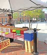 Timothy Christian, right, waits on Ralph Lee in continuing a 50-year family tradition of selling fruits and vegetables at the 17th Street Market in ShockoeBottom.(The name recently was changed from the 17th Street Farmers’ Market.) Mr. Christian is the lone regular vendor in the revamped, but still struggling market that has yet to regain its panache after a three-year facelift for which the city spent $3.5 million. Sisters Rosa Fleming and Evelyn Luceal Allen, other longtime vendors, have to be reinstated; they now sell produce from a stand on Franklin Street in a parking lot across from the market. (Sandra Sellars/Richmond Free Press)