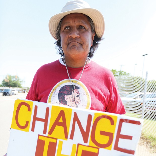 Stephen Rivera of Richmond carries his message on a sign outside the team’s training camp on West Leigh Street. He has picketed against the team’s racist name each year since the team began practicing in Richmond in 2013. He has no suggestion for a new name but says anything is fine “as long as it’s not something that denigrates native people or any of us.” A U.S. Supreme Court decision in June regarding “immoral” or “scandalous” trademarks may bolster the team’s legal efforts to keep its offensive, trademarked name.