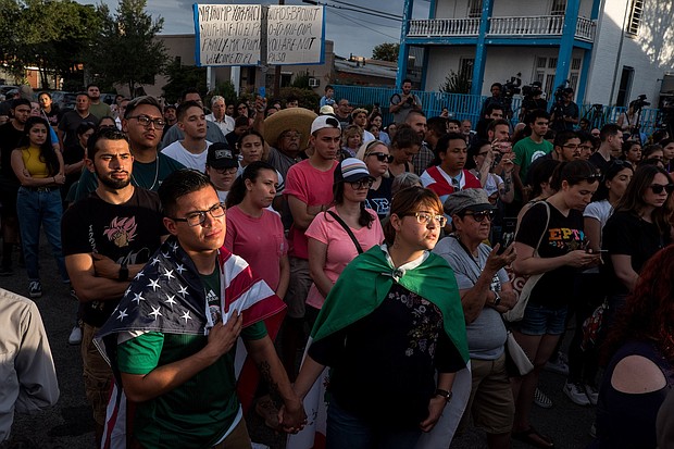 Cesar Antonio Pacheco, 24, left, and Samantha Ordaz, 20, both of El Paso, hold hands during a vigil.