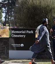 An armed policeman keeps watch as mourners arrive to attend funerals for victims killed in the mosque massacre in Christchurch, New Zealand.