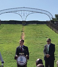 Gov. Ralph S. Northam speaks at a news conference Tuesday in front of the 50-foot memorial arch at Fort Monroe, showing that the letters honoring Confederate president Jefferson Davis have been removed. With the governor are, from left, state Sen. Mamie Locke of Hampton; Glenn Oder, executive director of the Fort Monroe Authority; and Molly J. Ward, former state secretary of natural resources and a former trustee of the authority.