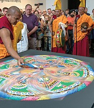 Sweeping away the mandala
Tibetan Buddhist monks from the Drepung Loseling Monastery in Southern India dismantle a sand mandala they constructed in early May at the Virginia Museum of Fine Arts in conjunction with the opening of the museum’s exhibit, “Awaken: A Tibetan Buddhist Journey Toward Enlightenment.” With the exhibit’s closing this week, the monks dismantled the mandala in a ceremony last Saturday, sweeping up the sand to symbolize the impermanence of all that exists. (photo by Ava Reaves)