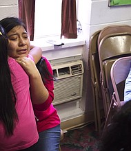 Sisters hug inside the Trinity Mission Center in Forest, Mississippi, after their father was detained by ICE agents.