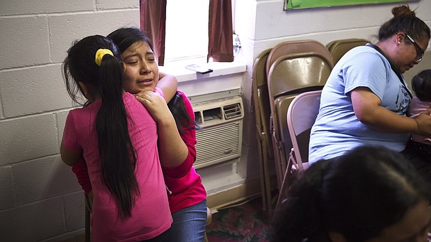 Sisters hug inside the Trinity Mission Center in Forest, Mississippi, after their father was detained by ICE agents.
