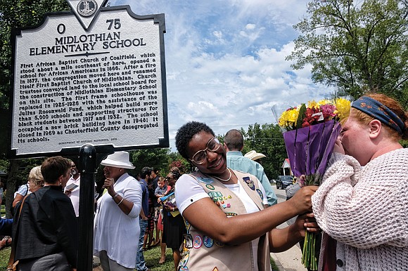 Deja Williams, left, of Midlothian Girl Scout Troop 635 accepts congratulatory flowers from her longtime friend, Jane McConville, after seeing ...