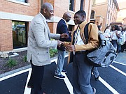Dontrese Brown, vice chair of the board of directors of Cristo Rey Richmond High School, greets freshman Joshua in a welcome line set up by board members and staff on the first day.