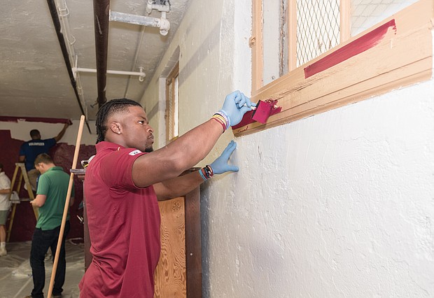 Washington running back Chris Thompson paints at Carver Elementary School during the team’s project to spruce up the laundry area. The project took place last month while the team was in Richmond at its preseason training camp.