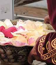 Calvin Pearson, founder of Project 1619, holds a bowl of rose petals in preparation for a ceremony in which people dropped the petals in the water off the pier at Fort Monroe in honor and remembrance of the millions of Africans brought to these shores during the trans-Atlantic slave trade. (photo by Ava Reaves)