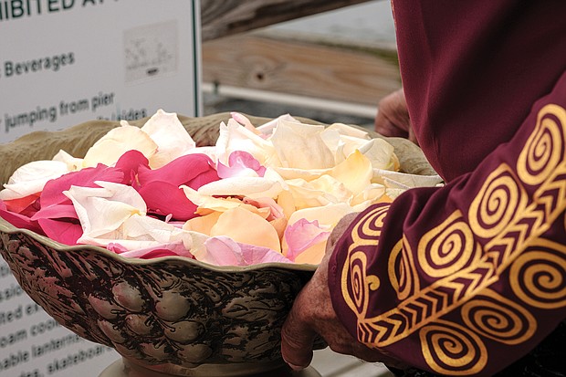 Calvin Pearson, founder of Project 1619, holds a bowl of rose petals in preparation for a ceremony in which people dropped the petals in the water off the pier at Fort Monroe in honor and remembrance of the millions of Africans brought to these shores during the trans-Atlantic slave trade. (photo by Ava Reaves)