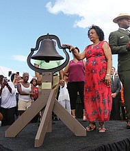 Ora McCoy, 76, of Appomattox, and Terry E. Brown, superintendent of Fort Monroe National Monument, launch the nationwide bell-ringing ceremony at 3 p.m. Sunday at Fort Monroe as part of the ceremony. Bells at national parks, churches and other places across the country rang for four minutes — one minute for each century — in honor of the first Africans in English North America 400 years ago. The bell belonged to Ms. McCoy’s family. (Regina H. Boone/Richmond Free Press)