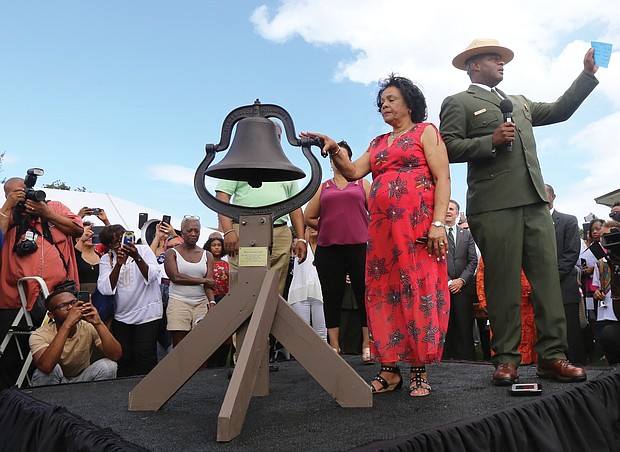 Ora McCoy, 76, of Appomattox, and Terry E. Brown, superintendent of Fort Monroe National Monument, launch the nationwide bell-ringing ceremony at 3 p.m. Sunday at Fort Monroe as part of the ceremony. Bells at national parks, churches and other places across the country rang for four minutes — one minute for each century — in honor of the first Africans in English North America 400 years ago. The bell belonged to Ms. McCoy’s family. (Regina H. Boone/Richmond Free Press)