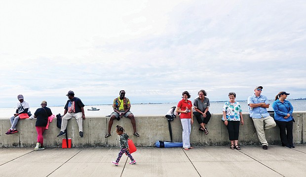 Lariah Harris, 2, of Hampton walks with confidence Saturday along Fort Monroe’s waterfront, where the first “20 and odd Negroes” came ashore as captives at Point Comfort in 1619. The youngster was following her grandmother, Dee Wesley, a resident on the Fort Monroe property, which is now a part of the National Park Service. (Regina H. Boone/Richmond Free Press)