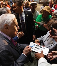 Former Virginia Gov. L. Douglas Wilder, a grandson of slaves and the first African-American elected governor in the nation, autographs a placard for a guest at the “African-American Political Pioneers” luncheon Friday at the Hampton Roads Convention Center. (photo by Brian Palmer)