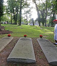 Tracy Richardson of Hampton looks at some of the marked gravesites at the Tucker Family Cemetery nestled in a residential area at 1 Sharon Court in Hampton. The cemetery holds the descendants of William Tucker, the first African-American born in the English colony of Virginia in 1624. According to records, William Tucker was the child of Anthony and Isabella, two of the first Africans brought to Virginia in 1619. (Regina H. Boone/Richmond Free Press)