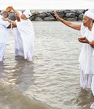 Queen mothers from the Institute of Whole Life Healing in Kentucky anoint participants at a sunrise cleansing and healing ceremony at Buckroe Beach in Hampton as part of the 400th anniversary commemoration of the first Africans landing in English North America.