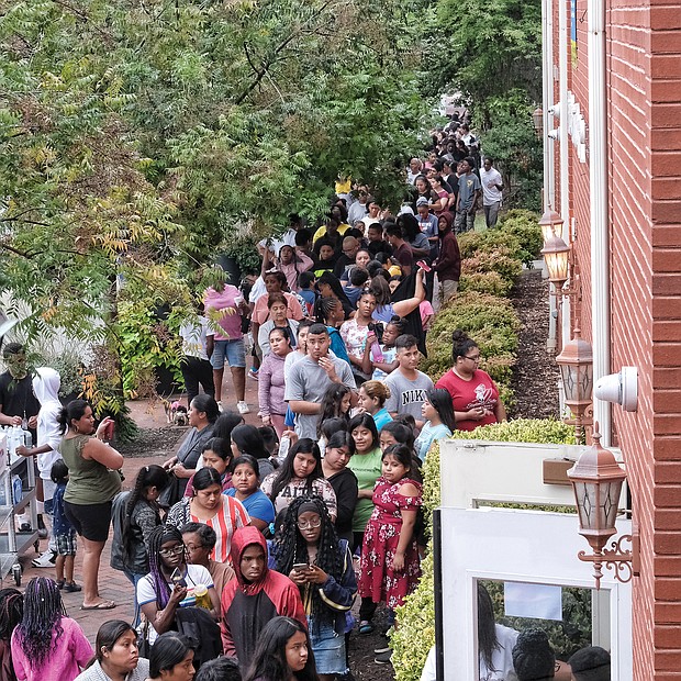 Hundreds of people line up outside the doors of Third Street Bethel A.M.E. Church in Jackson Ward on Monday for the 14th Annual Labor Day New Shoes for Back to School program. Students in kindergarten through high school could pick out a pair of new shoes to start the school year.