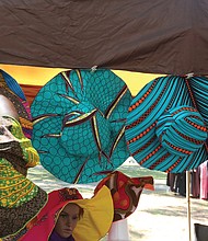 Georgia Bates of Henrico, above, adjusts the Ankara hats designed by her sister, Massa Watson, at a booth at the 2019 AfroFest RVA last Saturday. The event, sponsored by the city Department of Parks, Recreation and Community Facilities, was held at Pine Camp Cultural Arts and Community Center in North Side. It highlighted the culture, food, music and fashions of people from African nations living within the Richmond community, along with a championship soccer match between teams from Ghana and Sudan.