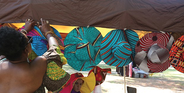 Georgia Bates of Henrico, above, adjusts the Ankara hats designed by her sister, Massa Watson, at a booth at the 2019 AfroFest RVA last Saturday. The event, sponsored by the city Department of Parks, Recreation and Community Facilities, was held at Pine Camp Cultural Arts and Community Center in North Side. It highlighted the culture, food, music and fashions of people from African nations living within the Richmond community, along with a championship soccer match between teams from Ghana and Sudan.