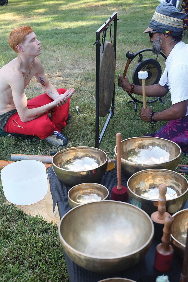 Julian Desta, right, leads an individual sound healing bath session for Russell Gray. It was Mr. Gray’s first time undergoing the healing.