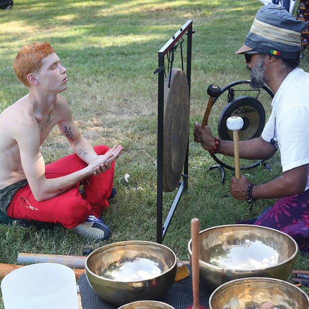 Julian Desta, right, leads an individual sound healing bath session for Russell Gray. It was Mr. Gray’s first time undergoing the healing.