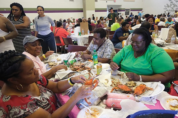 A real feast/ Hundreds of people are in crab heaven at the all-you-can-eat Crab Feast & Fish Fry held last Saturday by the Men of St. Peter’s Episcopal Church at Peter Paul Development Center in the East End. The annual event benefits the outreach and community center that serves seniors and after-school programs for youngsters. Enjoying the meat they picked from crabs are, seated clockwise from left, Rhonda Thorpe, Delores Key, Catherine Rob- inson and Nicole Robinson. (Sandra Sellars/Richmond Free Press)