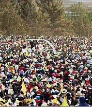 Pope Francis, background center, is cheered by a crowd of faithful last Sunday as he arrives in the popemobile to celebrate Mass in Antananarivo, Madagascar. The pope was in Madagascar for the second leg of his weeklong trip to Africa.