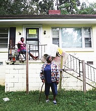 The Lewis sisters in front of the condemned house on Flynn Road in South Side that they no longer are allowed to live in.