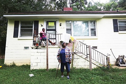 The Lewis sisters in front of the condemned house on Flynn Road in South Side that they no longer are allowed to live in.