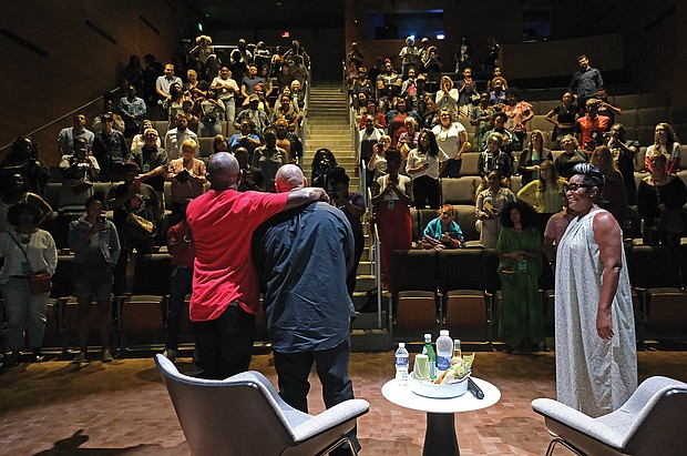 The audience at the Afrikana Independent Film Festival gives a standing ovation last Saturday to Raymond Santana, center, after the screening of the documentary “The Central Park Five.” Mr. Santana, who was exonerated in the case after spending five years in prison, talked about his experience following the film. He is embraced by Todd Waldo, adviser for the film festival, while moderator Zoe Spencer, a sociology professor at Virginia State University, looks on.