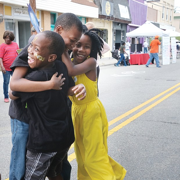 We won! The Aryee siblings — from left, Caleb, 9; Othneil, 12; and Zari, 9 — celebrate after learning they won a bicycle in a raffle at the 6th Annual Brookland Park Community Celebration last Saturday in North Side. The event, sponsored by the Historic Brookland Park Collective, featured food, music and fellowship along West Brookland Park Boulevard that was closed to traffic. The youngsters used the no traffic zone to happily and freely road test their new bike. (Sandra Sellars/Richmond Free Press)