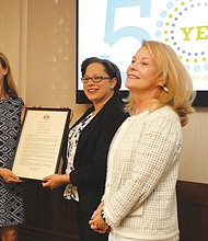 Daily Planet board chair Elizabeth Roark, left, is presented a General Assembly resolution recognizing the Daily Planet’s 50 years of service to people in Central Virginia from state Sen. Jennifer McClellan of Richmond. Beth Merchant, chief executive officer of the Daily Planet, right, also participated in the presentation held Aug. 7 at the organization’s West Grace Street headquarters.