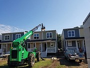 A crane brings solar panels to the installation crew.