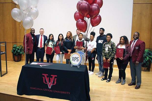 Ninth-graders at Huguenot High School are honored with four-year scholarships to Virginia Union University on Tuesday during a surprise ceremony with officials at the South Side school. Award winners and the officials are, from left, Maurice Campbell, VUU’s senior vice president of corporate and external affairs; Richmond Public Schools Superintendent Jason Kamras; April Leveron; Ashley Duron; Asia Dudley; Huguenot Principal Robert J. Gilstrap; Demarc Oliver; Ingrid Reyes Rodas; Jordan Braxton; Mekhi Reavis; Shayla Saravia; and Mike Newsome, president of the VUU National Alumni Association. Award winner Justin Pair is not pictured.