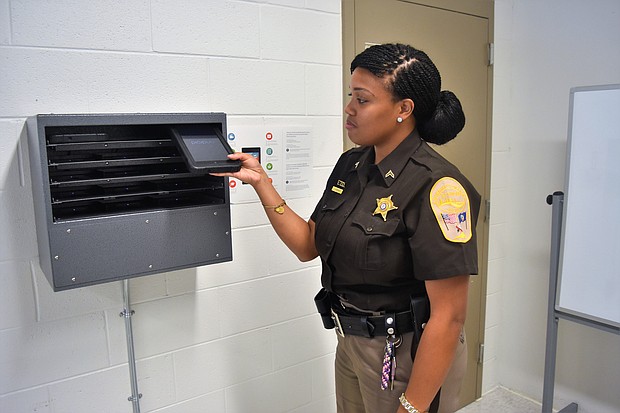Cpl. J. Barnes pulls one of the tablets from a charging station, also called a “pizza oven.”