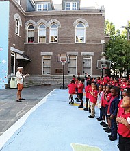 Students at St. Andrew’s School join art teacher Chris Milk on Monday to get their first look at the mural  they all helped create to mark the 125th year of the private school based in Oregon Hill.