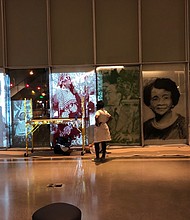 Artist Tomashi Jackson pauses to look at her installation of drawings on glass honoring African- Americans from Virginia at Virginia Commonwealth University’s Institute for Contemporary Art. Her installation, titled “Monument of Color (Red, Black, and Green)” is part of the ICA’s “Great Force” exhibit opening Friday, Oct. 4. Among the portraits featured is one of Raymond H. Boone, left, the late founder and former publisher of the Richmond Free Press.