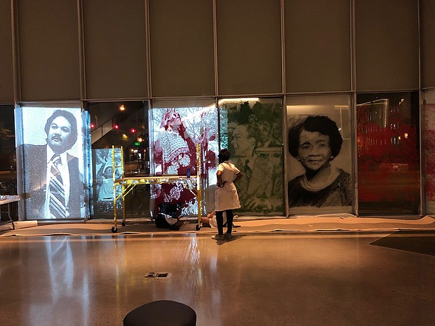 Artist Tomashi Jackson pauses to look at her installation of drawings on glass honoring African- Americans from Virginia at Virginia Commonwealth University’s Institute for Contemporary Art. Her installation, titled “Monument of Color (Red, Black, and Green)” is part of the ICA’s “Great Force” exhibit opening Friday, Oct. 4. Among the portraits featured is one of Raymond H. Boone, left, the late founder and former publisher of the Richmond Free Press.