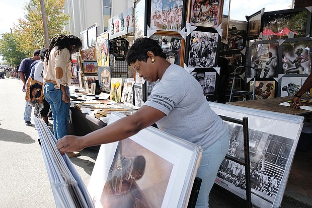 Caroline Johnson peruses art for sale by one of the many vendors and merchants at the 31st Annual 2nd Street Festival. (Sandra Sellars/Richmond Free Press)