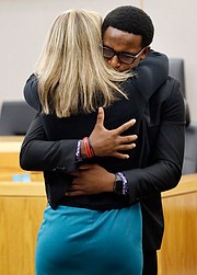 Brandt Jean, 18, hugs Amber Guyger, the former Dallas police officer convicted of murder in the death of his older brother, Botham Jean. The two embraced after he delivered his impact statement during the trial’s sentencing phase.