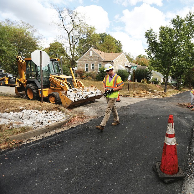 The Fulton neighborhood in the East End is one of the first to get new paving as part of a $15 million program City Hall is undertaking during the current 2019-20 budget year. While one lane on Carlisle Avenue is complete, a city crew on Monday repairs the second lane at the intersection of Carlisle Avenue and Malone Street before repaving. (Regina H. Boone/Richmond Free Press)